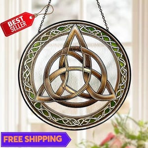 May include: Round stained glass window art featuring a Celtic knot design in shades of brown and gold. The window is framed with a green and brown border and hangs from a chain. A red tag reads "BEST SELLER".