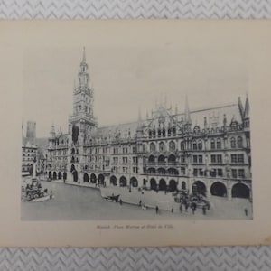 May include: A vintage black and white postcard featuring a detailed architectural rendering of a large building with a tall tower. The postcard has the text "Munich, Place Maren at Hotel de Ville."