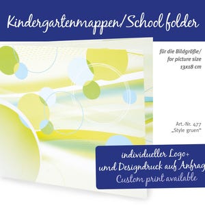 May include: A school folder with a design of yellow and green circles and lines. The folder has text that says "Kindergartenmappen/School folder" and "Custom print available". The folder is designed for a picture size of 13x18 cm.