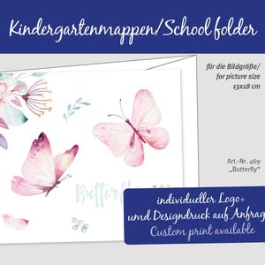 Könnte beinhalten: Ein weißer Schulordner mit Aquarellillustrationen von rosa Schmetterlingen und floralen Akzenten. Der Ordner enthält Text auf Deutsch und Englisch, mit einer Größe von 13x18 cm. Individuelle Druckoptionen sind verfügbar.