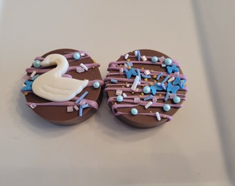 Milk Chocolate covered Fudgeeo with white chocolate swan (other decorations available). Cellophane packed in sets of 2.