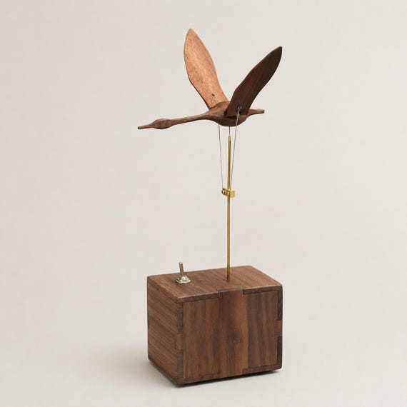 A hand-carved wooden swan that actually flaps and moves — pure mechanical magic you can put on your desk.