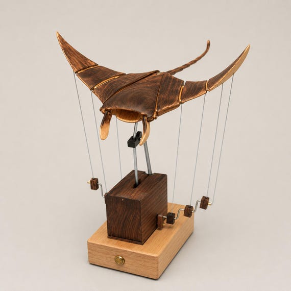 A USB-rechargeable wooden manta ray that actually 'flies' through the air via mechanical motion — handcrafted automaton engineering meets ocean sculpture.