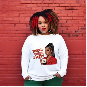 May include: White sweatshirt with the text "Blessed, Bougie & Merry" in red script. The graphic features a woman in a red blazer holding a mug with a Santa design. The woman has long black hair and is wearing red lipstick.