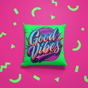 May include: A green pillow with the words "Good Vibes" in colorful, stylized lettering. The pillow is on a pink background with green geometric shapes.