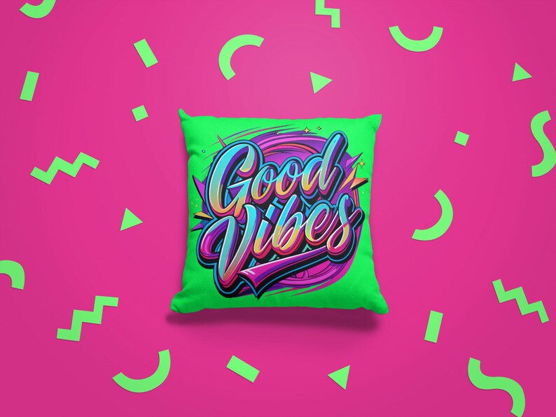 May include: A green pillow with the words "Good Vibes" in colorful, stylized lettering. The pillow is on a pink background with green geometric shapes.