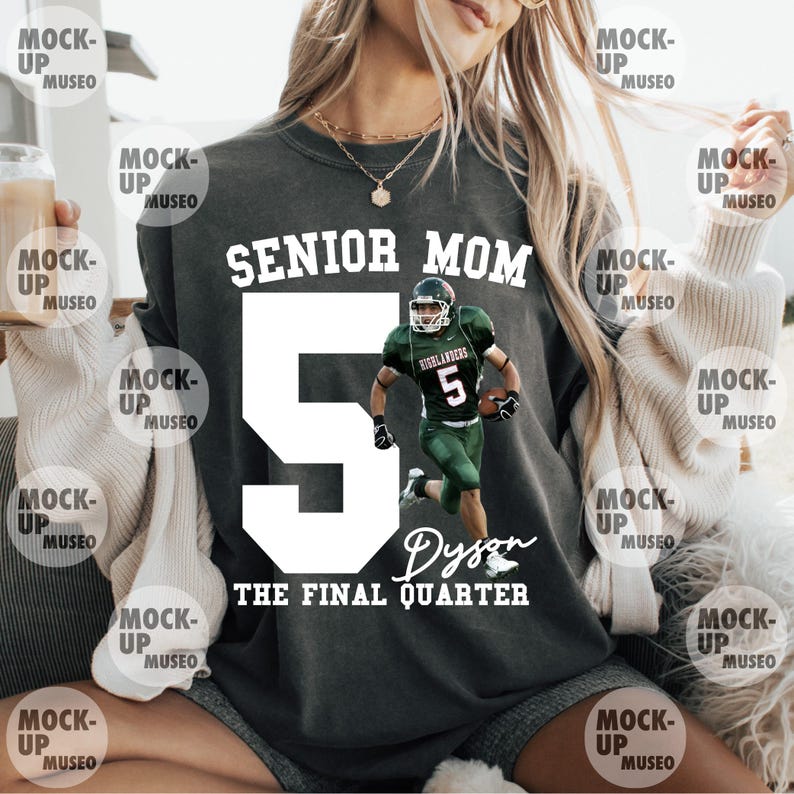 May include: Dark gray sweatshirt with the text "SENIOR MOM" above a large white number 5 and a football player graphic. The name "Dyson" and "THE FINAL QUARTER" are printed below the number. A casual, comfortable top.