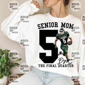 May include: White sweatshirt featuring the text "SENIOR MOM" above a large black number 5 and a football player in green and white uniform. The text "THE FINAL QUARTER" and a name are below the number. A casual, sporty design.