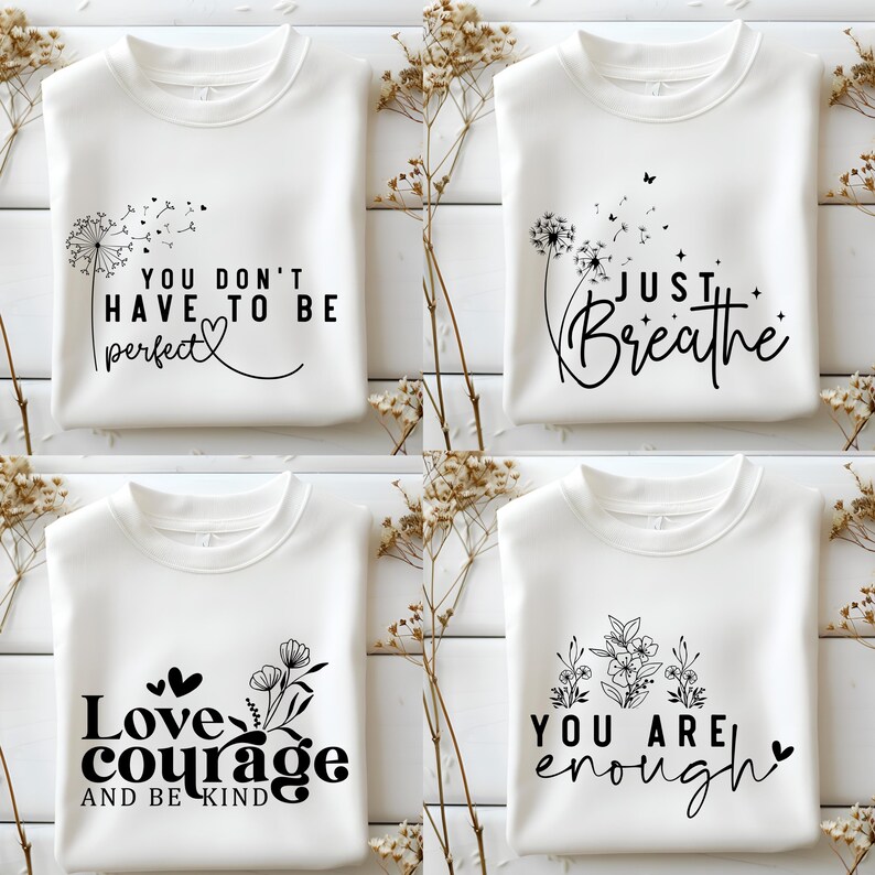 May include: Four white sweatshirts with different inspirational quotes and designs printed on them. The quotes are "You don't have to be perfect", "Just Breathe", "Love courage and be kind", and "You are enough".
