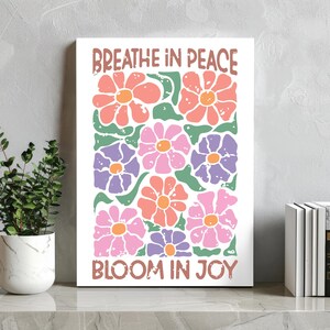 Może przedstawiać: Biały nadruk na pł&oacute;tnie z kwiatowym wzorem i napisami "Breathe in Peace" i "Bloom in Joy". Kwiaty są w odcieniach r&oacute;żu, pomarańczy i fioletu z zielonymi liśćmi. Idealny do dekoracji wnętrz.