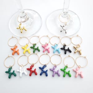 May include: Set of 12 colourful balloon dog shaped wine glass charms. Each charm features a different colour balloon dog on a gold ring.