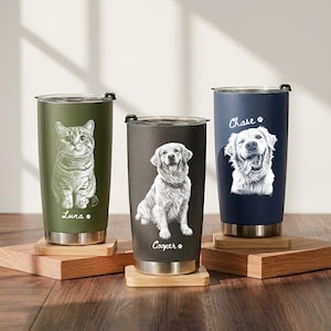 May include: Three stainless steel tumblers with lids, featuring custom pet portraits and names. The olive green tumbler shows a cat named Luna, the charcoal gray tumbler shows a dog named Cooper, and the navy blue tumbler shows a dog named Chase.
