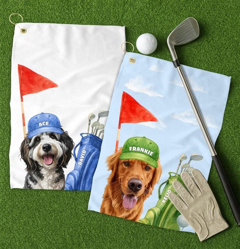 May include: Two golf towels with dog illustrations. One towel is white with a black and white dog wearing a blue cap that says "ACE". The other towel is blue with a golden retriever wearing a green cap that says "FRANKIE". A golf ball, club, and glove are also present.