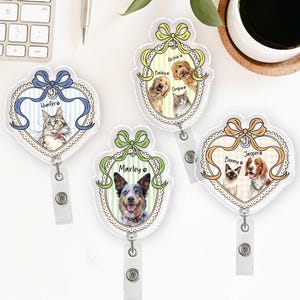 May include: Four clear acrylic pet ID badge holders with different pet portraits. Each badge features a bow, a pet's name, and a retractable reel. The pets include a cat, a dog, and a cat and dog duo.
