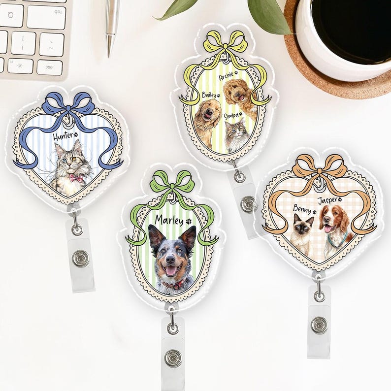May include: Four clear acrylic pet ID badge holders with different pet portraits. Each badge features a bow, a pet's name, and a retractable reel. The pets include a cat, a dog, and a cat and dog duo.