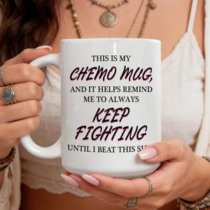 May include: White ceramic mug with the text "THIS IS MY CHEMO MUG, AND IT HELPS REMIND ME TO ALWAYS KEEP FIGHTING UNTIL I BEAT THIS S". The text is in black and pink. The mug has a large handle.