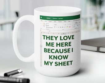Könnte beinhalten: Weiße Keramiktasse mit einer grünen Textgrafik, die "Sie lieben mich hier, weil ich meine Tabelle kenne" lautet. Die Grafik ist eine stilisierte Darstellung einer Tabellenkalkulationsanwendung.