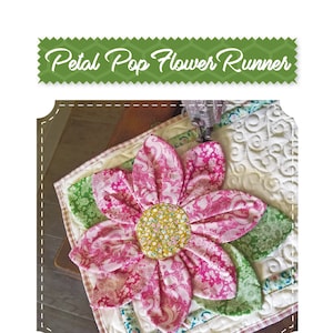 Może przedstawiać: Różowo-zielony bieżnik stołowy w kształcie kwiatu z pikowanym wzorem. Bieżnik przedstawia duży różowy kwiat z żółtym środkiem i zielonymi liśćmi. Tekst "Sugar Bee Quilts" jest widoczny w prawym dolnym rogu obrazu.