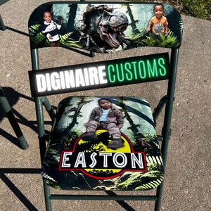 May include: A green folding chair with a custom design featuring a dinosaur and the name "Easton". The chair's backrest displays a T-Rex illustration and two children. The text "DIGINAIRE CUSTOMS" is also visible.
