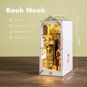 Op de afbeelding: Een witte DIY Book Nook met een miniatuur straatbeeld binnenin, met een koffiehuis en trappen. Het model is 24 cm hoog, 18 cm breed en 10 cm diep. De tekst zegt "Book Nook", "DIY Craft", "Assembly Hour: 6h", "Stylish Bookend" en "Luminous Decor".