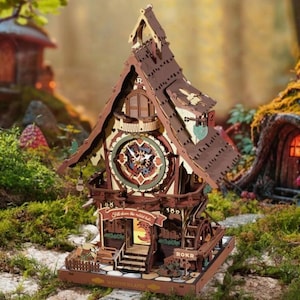 May include: A wooden cuckoo clock with a whimsical design. The clock features a detailed facade with a clock face, a small staircase, and the text "Fall down the rabbit hole." The clock is brown and beige, with a rustic aesthetic.