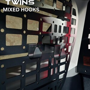 May include: Black metal cargo rack with a grid pattern and two hooks. The rack is labeled "YOTA TWINS MIXED HOOKS".