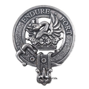 May include: A silver-toned clan crest featuring a stylised bird design with the words "Endure Fort" around the edge.