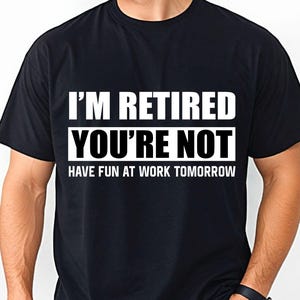 May include: A black short-sleeved t-shirt featuring white text printed on the chest that reads I'M RETIRED YOU'RE NOT HAVE FUN AT WORK TOMORROW. The shirt has a crew neckline and a standard fit, providing a clear view of the bold lettering.