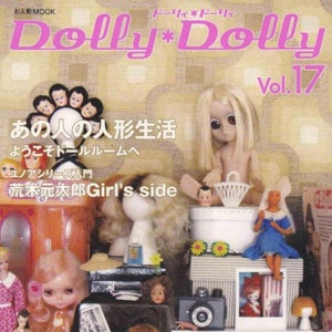 May include: A magazine cover featuring a group of dolls with large eyes. The magazine is titled "Dolly*Dolly" and the cover features the text "あの人の人形生活" which translates to "That person's doll life" in English. The magazine is Vol. 17.