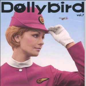 Può includere: Una copertina di rivista vintage con una donna che indossa un'uniforme rosa e un cappello rosa con uno spillo dorato. La rivista è intitolata "Dollybird Airline" e il numero del volume è "vol.7".