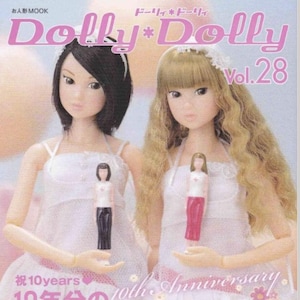 May include: A magazine cover featuring two dolls with blonde and black hair wearing white dresses. The magazine is titled "Dolly*Dolly Vol. 28" and has the text "10th Anniversary 10年分のmomoko総カタログ" in pink and white.