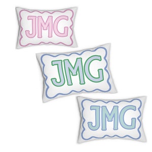 May include: Three white pillow covers with scalloped edges. Each pillow cover features the monogram "JMG" in a different color: pink, green, and blue.