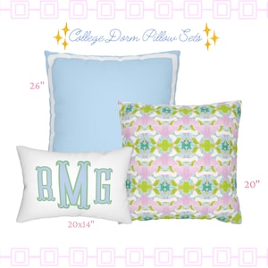May include: A set of three pillows labeled College Dorm Pillow Sets. One large 26-inch light blue square pillow, one 20-inch square pillow with a pink, green, and blue abstract pattern, and one 20 by 14-inch white rectangular pillow with the monogram RMG.