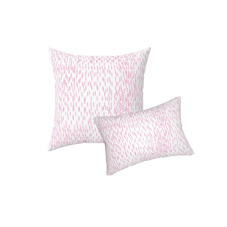 May include: A square throw pillow and a rectangular throw pillow, both featuring a white base colour with a repeating pattern of small, vertical, light pink dash marks distributed across the entire surface of the fabric covers.