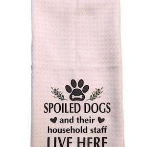 May include: White hanging kitchen towel with a black quilted top and a decorative pearl button. The towel features the text "SPOILED DOGS and their household staff LIVE HERE" with a paw print and bone graphic.