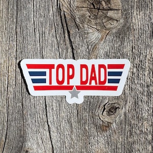 May include: A white sticker with red and blue stripes and a star. The sticker says "TOP DAD" in red letters.