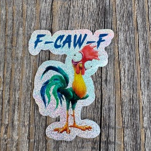 May include: A glittery sticker featuring a cartoon rooster with a red comb and yellow chest. The rooster has a green and blue tail and is standing on orange feet. The text "F-CAW-F" is above the rooster in blue.