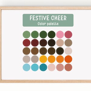 May include: A framed print displaying a colour palette labelled "Festive Cheer." The palette presents a grid of coloured circles, including greens, pinks, browns, and oranges. The frame is made of light-coloured wood.