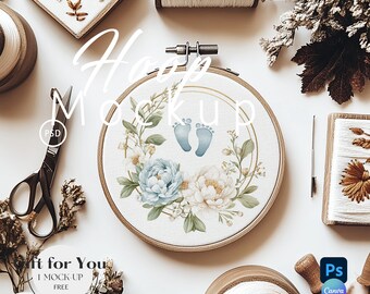 Puede incluir: Un bastidor de bordado con un diseño floral y huellas de bebé, rodeado de materiales de costura. El bastidor presenta un arreglo floral azul y blanco con el texto "Hoop Mockup". Otros elementos incluyen tijeras, hilo y una aguja.