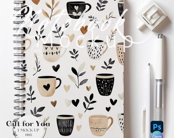May include: A white notebook with a spiral binding and a black and white pattern of coffee cups, leaves, and hearts. The text "Gift for You" is printed on the front cover. The notebook is on a white surface.