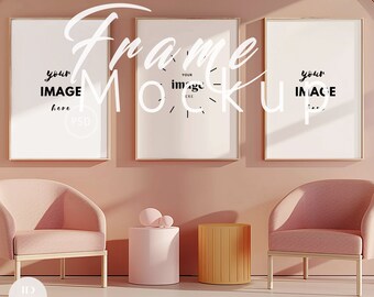 May include: Three gold framed picture mockups with white mats on a pink wall. The frames are hanging on the wall above two pink armchairs and two side tables. One side table is pink and the other is orange.