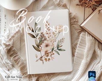 Puede incluir: Un libro blanco con un diseño floral con flores rosas y beige, hojas verdes y detalles marrones. Las palabras "Book Mockup" están escritas en la parte superior. Una taza de café y otros elementos decorativos están en el fondo.