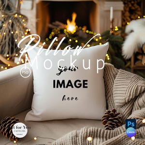 May include: White pillow mockup with the text "Pillow Mockup your IMAGE here" on a couch with a brown knitted throw blanket and a pine cone.