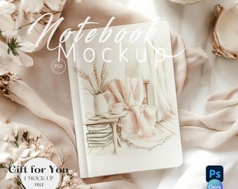 May include: A white notebook mockup with a watercolor illustration of a cozy room with a chair, a blanket, a vase with dried flowers, and a stack of books. The notebook is on a white surface with a white fabric and flowers.