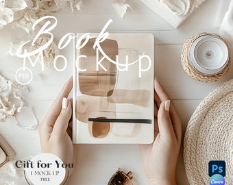 May include: A book mockup with a brown and white abstract design cover. The book is being held by hands on a white surface with other decorative items.