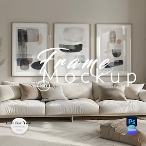 Könnte beinhalten: Drei gerahmte abstrakte Kunstdrucke mit schwarzen, weißen und beigefarbenen geometrischen Formen auf weißem Hintergrund. Die Rahmen sind in hellem Holz gehalten und hängen an einer hellgrauen Wand über einem weißen Sofa mit Kissen. Das Sofa steht vor einem hellgrauen Teppich.