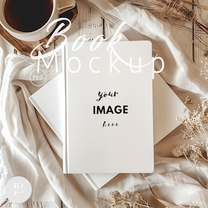 May include: A white book mockup with the text "your IMAGE here" on the cover, lying on a white fabric with dried flowers and a wooden surface.