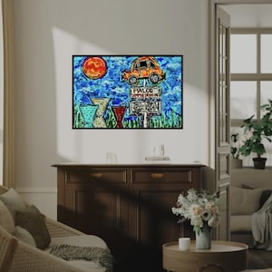 May include: A framed artwork featuring a whimsical orange car atop a sign that reads "MALCO SIMPLE DRIVE IN". The background includes a blue sky, a red sun, and stylized green grass.