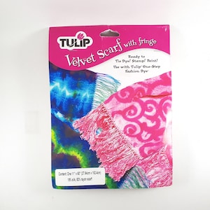 May include: A package for a Tulip velvet scarf with fringe. The package is pink and features a tie-dye design in blue, green, and pink. The scarf measures 11" x 60" and is made of 18% silk and 82% rayon. The package text says "Ready to Tie Dye! Stamp! Paint!"