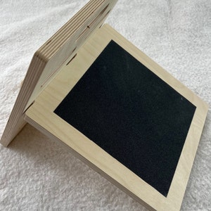 Op de afbeelding: Een houten hellingsbord met een zwart antislip oppervlak. Het bord is gemaakt van multiplex en heeft een natuurlijke houtkleur.
